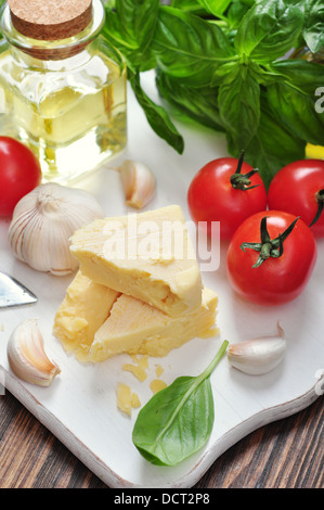 Fromage parmesan avec tomates et basilic dans l'arrière-plan Banque D'Images