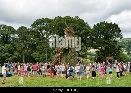 Les amateurs du Festival dansent autour d'une sculpture géante de Green Man lors du festival annuel de musique Green Man, Glanusk, Crickhowell, pays de Galles, Royaume-Uni Banque D'Images