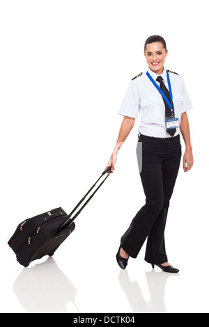 Belle jeune femme en uniforme de pilote de ligne marche avec porte-documents sur fond blanc Banque D'Images