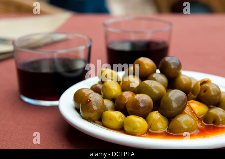 L'Espagnol apéritif : olives vertes et deux verres de vin rouge. Voir de très près. Banque D'Images