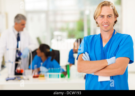 Cheerful chercheur médical avec les bras croisés dans le laboratoire Banque D'Images