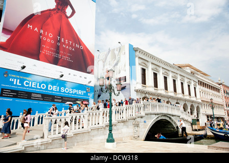 Des foules de touristes walking over bridge à côté de Palais des Doges, Venise, avec des gondoles. Banque D'Images