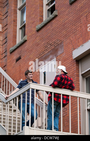 Deux jeunes hommes à une discussion sérieuse sur un balcon Banque D'Images