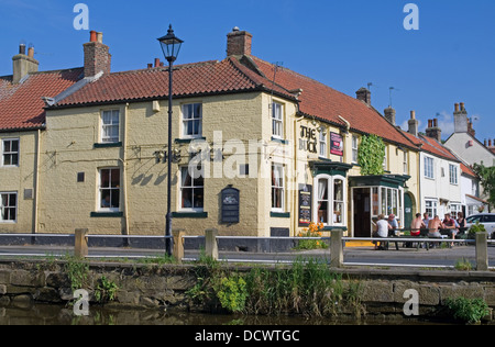 La Buck Inn, Great Ayton, par la rivière Leven, chaud après-midi d'été, les gens assis dehors, North Yorkshire Angleterre UK Banque D'Images