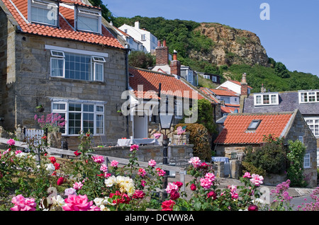 Gîtes traditionnels en pierre avec toit de tuiles rouges à Runswick Bay, Rose Garden en premier plan, North Yorkshire Angleterre UK Banque D'Images