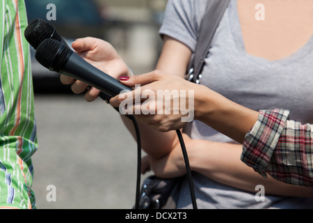 Un journaliste fait une interview avec un microphone Banque D'Images