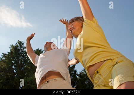 Laughing couple saute en l'air Banque D'Images
