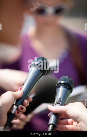 Un journaliste fait une interview avec un microphone Banque D'Images