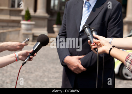 Un journaliste fait une interview avec un microphone Banque D'Images