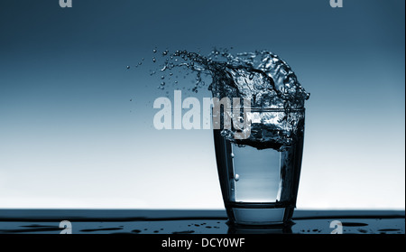 L'eau potable est versé d'une bouteille dans un verre Banque D'Images