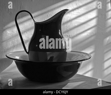 Une photo en noir et blanc d'une cruche et bol dans une salle de bains. Banque D'Images