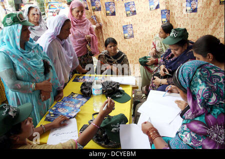 Les électeurs de vérifier leurs noms dans la liste des électeurs pour l'exercice de leur droit de vote à l'extérieur d'un bureau de vote à la Ligue musulmane-N camp lors d'élections partielles pour le PP-142 à Lahore le Jeudi, 22 août 2013. L'interrogation pour les 41 sièges de l'Assemblée nationale et provinciale dans les quatre provinces et Islamabad dans l'élection partielle a conclu à 5:00 PM et le processus de dépouillement des votes était en cours. Banque D'Images