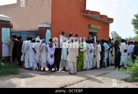 Position dans la file d'électeurs à exercer leur droit de vote à l'extérieur d'un bureau de scrutin lors d'élections partielles pour le NA-177 au salon Muzaffargarh à Multan jeudi, 22 août 2013. L'interrogation pour les 41 sièges de l'Assemblée nationale et provinciale dans les quatre provinces et Islamabad dans l'élection partielle a conclu à 5:00 PM et le processus de dépouillement des votes était en cours. Banque D'Images