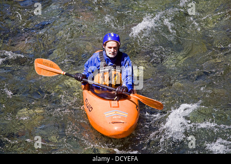 Une personne âgée la kayakiste sur la partie supérieure de la rivière McKenzie dans le centre de l'Oregon Cascade Mountains. Banque D'Images