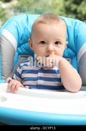 Assis dans une chaise haute bébé Banque D'Images