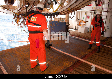 Gun mécaniciens travaillant sur les armes à air comprimé armes sismiques au pont dans l'océan des navires sismologiques Europe, RXT company, travaillant pour Petrobras Banque D'Images