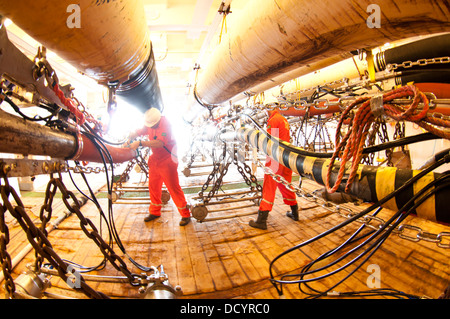 Gun mécaniciens travaillant sur les armes à air comprimé armes sismiques au pont dans l'océan des navires sismologiques Europe, RXT company, travaillant pour Petrobras Banque D'Images