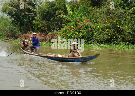 L'homme et la femme se déplaçant le long de la rivière du Mékong sur un petit bateau à moteur. Vinh Long, Delta du Mékong, Vietnam. Banque D'Images