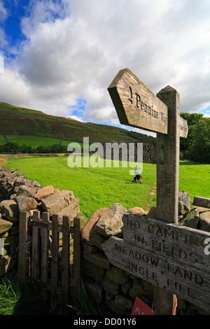 Walker sur le Pennine Way dans la position de Thwaite, Swaledale, Yorkshire du Nord, Yorkshire Dales National Park, England, UK. Banque D'Images