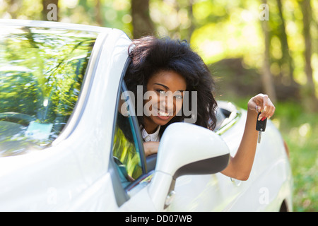 Les jeunes adolescentes belle black driver holding car keys conduisant sa nouvelle voiture Banque D'Images