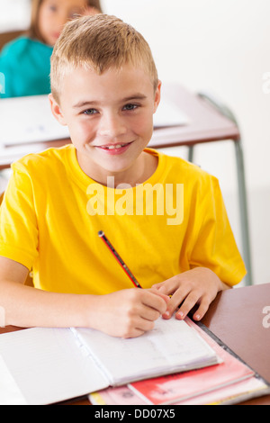 Adorable élève d'école élémentaire en classe d'écriture en classe Banque D'Images