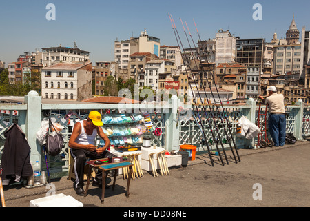 Pêche à l'homme et l'homme de vendre le matériel sur le pont de Galata, Istanbul, Turquie Banque D'Images