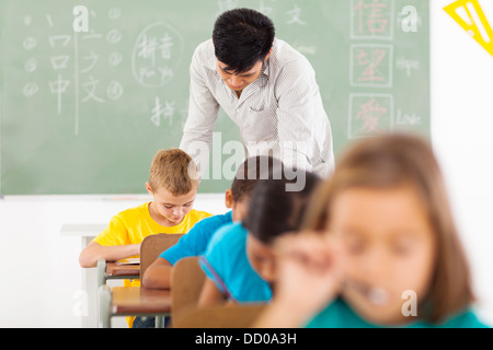 Professeur de langue chinoise mâle en classe avec un groupe d'élèves du primaire Banque D'Images