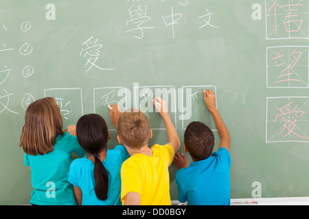 Vue arrière de l'école élémentaire l'apprentissage du chinois écrit on chalkboard Banque D'Images