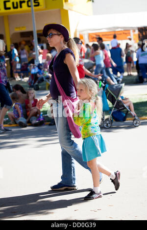 Maman marcher avec sa jeune fille en tenant à la foire d'activités. Minnesota State Fair jour d'ouverture le jeudi 22 août 2013 St Paul Minnesota MN USA Banque D'Images