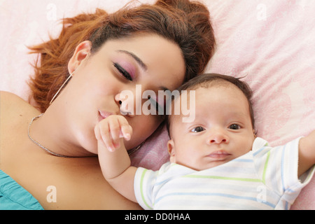 Hispanic mother kissing son bébé la main. L'accent sur la mère. Banque D'Images