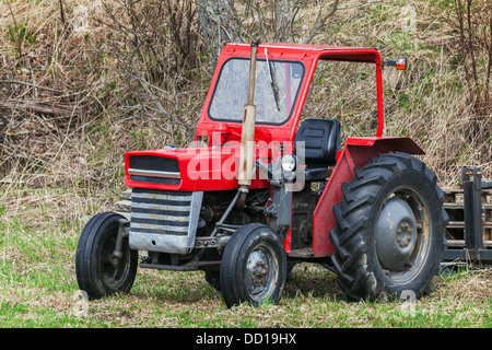 Petit tracteur rouge se tient sur l'herbe en Norvège Banque D'Images