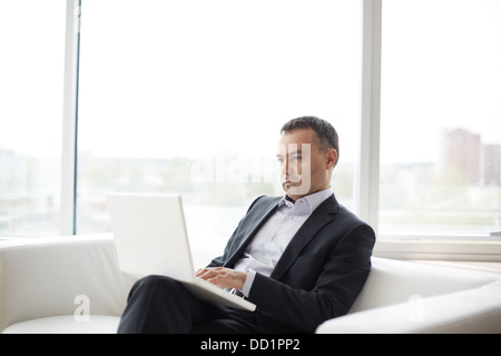 Serious businessman working on laptop in office Banque D'Images