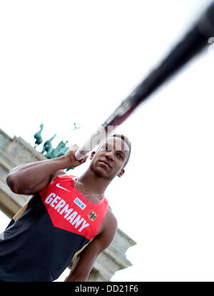 L'athlète allemand Raphael Holzdeppe pose avec un poteau en face de la porte de Brandebourg à Berlin, Allemagne, 23 août 2013. L'athlète doit participer à l'événement 'Berlin vole !" le 24 août. Un total de huit finalistes de la Coupe du Monde à Moscou prendront part à la compétition. Photo : RAINER JENSEN Banque D'Images