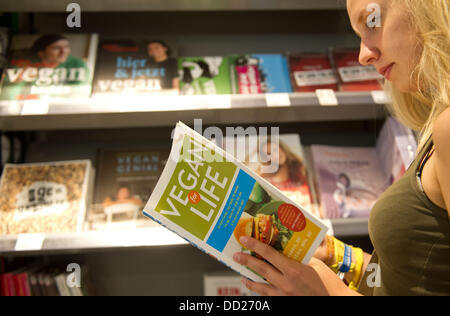 Une femme lit un livre de Cuisine vegan végétalien dans le supermarché 'Veganz' à Berlin, Allemagne, 22 août 2013. Photo : Spata Ole Banque D'Images