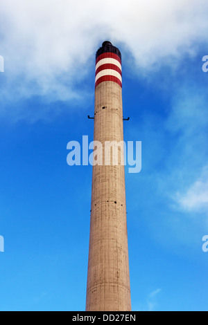 Cheminées de raffinerie produire de la fumée contre le ciel bleu Banque D'Images