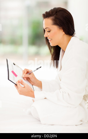 Jeune femme avec l'écriture du test de grossesse sur la planification du calendrier de sa grossesse Banque D'Images