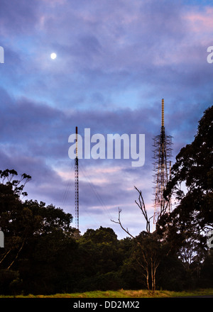 Téléphone portable mâts dans le bush australien, sous une pleine lune et un ciel crépusculaire rose et pourpre. La technologie rencontre la nature Banque D'Images