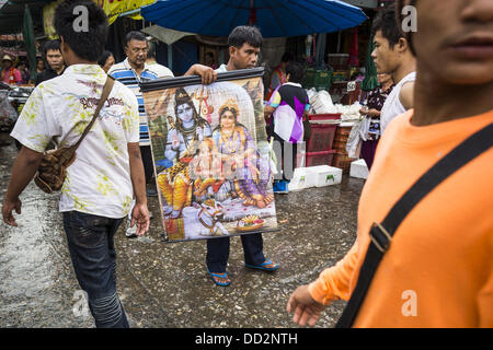 24 août 2013 - Bangkok, Thaïlande - Un homme essaye de vendre une peinture de divinités hindous Shiva, Ganesha et Parvati dans une rue de Bangkok. La Thaïlande est entré dans une technicalÃ Ã¢ ? ?¢ ?Â récession ce mois après que l'économie s'est contractée de 0,3  % au deuxième trimestre de l'année. La contraction de 0,3  % du produit intérieur brut entre avril et juin, suivie d'une chute de 1,7  % au cours du premier trimestre de 2013. La contraction est imputée à une baisse de la demande pour les exportations, une baisse de la demande intérieure et une perte de confiance des consommateurs. En même temps, la valeur du baht thaïlandais par rapport au dollar US a drop Banque D'Images