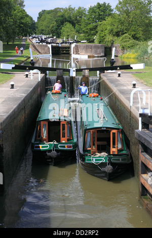 Deux narrowboats en ordre décroissant en chambre double écluse n° 43 de la Hatton Locks vol sur le Grand Union Canal juste en dehors de Warwick Banque D'Images
