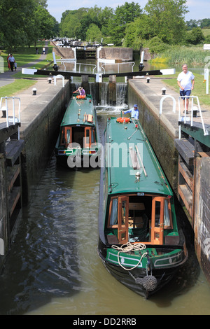 Deux narrowboats en ordre décroissant en chambre double écluse n° 43 de la Hatton Locks vol sur le Grand Union Canal juste en dehors de Warwick Banque D'Images