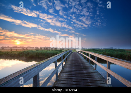 Pont de bois sur la rivière à l'aube d'été Banque D'Images