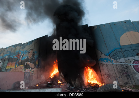 Un feu brûle à une tour dans le mur de séparation israélien suite aux affrontements dans le camp de réfugiés de Aida dans la ville cisjordanienne de Bethléem Banque D'Images