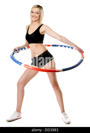 Jeune fille sportive pleine longueur faisant de l'exercice avec hula hoop. Femme Fitness isolated on white Banque D'Images