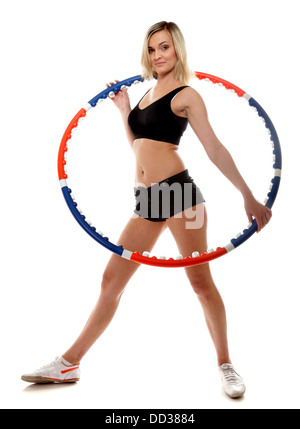 Jeune fille sportive pleine longueur faisant de l'exercice avec hula hoop. Femme Fitness isolated on white Banque D'Images