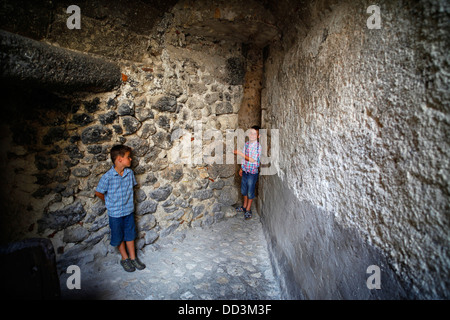 Deux garçons dans une petite ruelle dans le village médiéval de Santo Stefano di Sessanio, Abruzzo, Italie. Banque D'Images