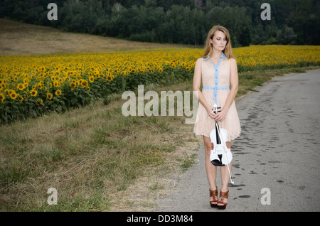 Jeune femme seule est au violon par country road Banque D'Images