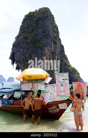 Les gens d'acheter de la nourriture dans un restaurant bateau ancré sur la plage de Hat Phra Nang Railay dans l'île heureuse avec en arrière-plan. Banque D'Images