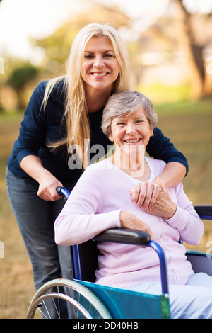 Happy senior femme dans un fauteuil roulant et sa fille au parc Banque D'Images