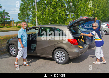 Couple de 70 ans d'entrer dans la nouvelle voiture Pori Finlande Europe du nord Banque D'Images