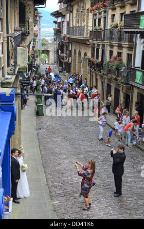 Wedding couple ayant leurs photos prises dans une rue pittoresque de la vieille ville de Hondarribia Banque D'Images